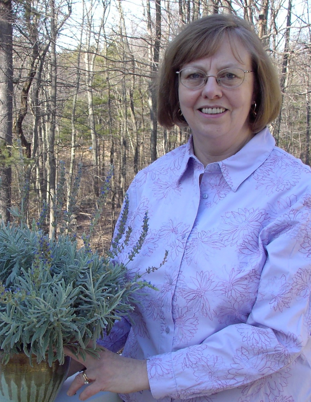 Betty Sanders holding a plant in a container 